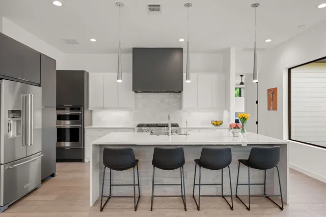 a kitchen with stainless steel appliances a sink and a refrigerator