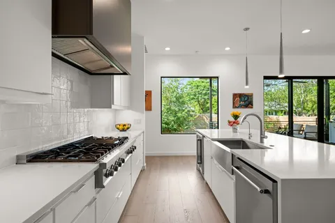 a kitchen with kitchen island granite countertop a stove and a sink