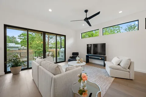 a living room with furniture tv and a large window