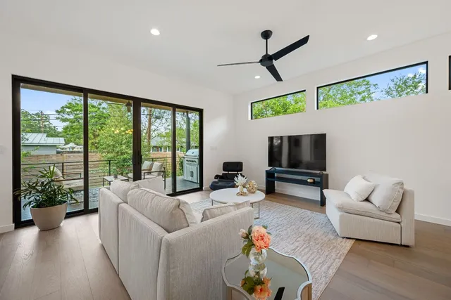 a living room with furniture tv and a large window