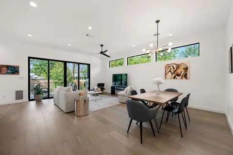 a dining room with furniture a chandelier and wooden floor