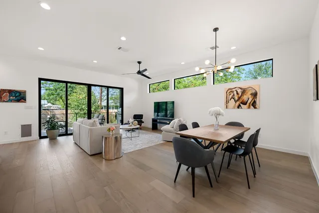 a dining room with furniture a chandelier and wooden floor