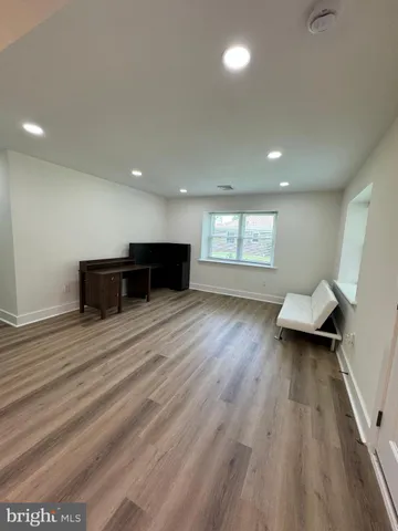 a view of empty room with wooden floor and window