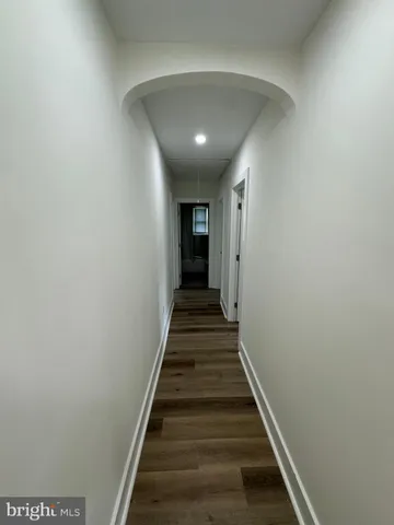 a view of a hallway with wooden floor and entryway