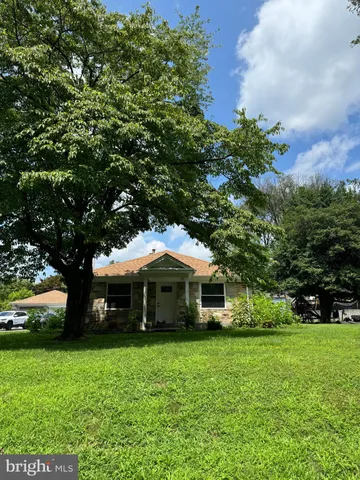 a front view of a house with yard and green space