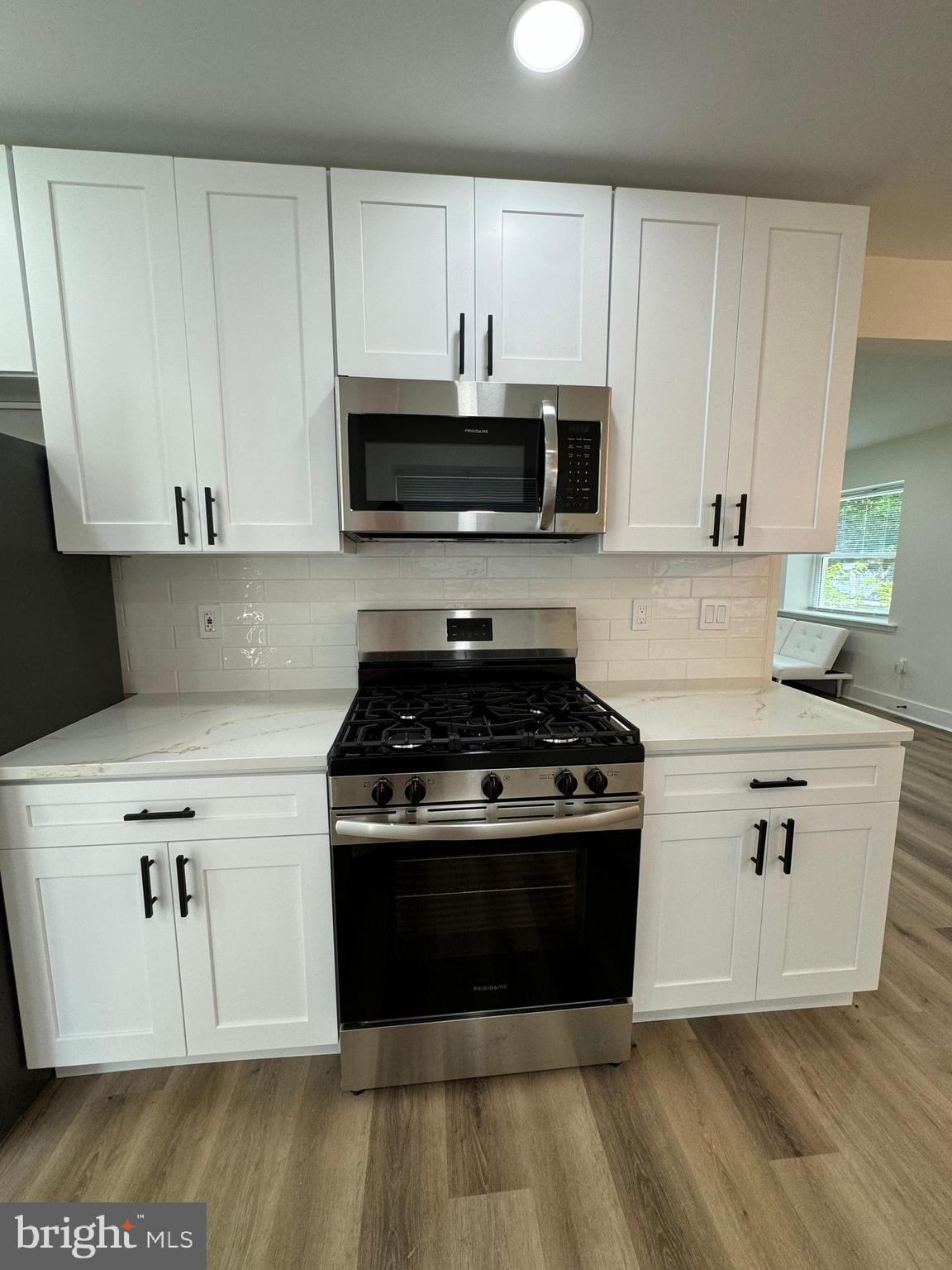 8606 Verree Road Philadelphia, PA 19115 - Photo 7 of 40 a white kitchen with wooden floor and stainless steel appliances