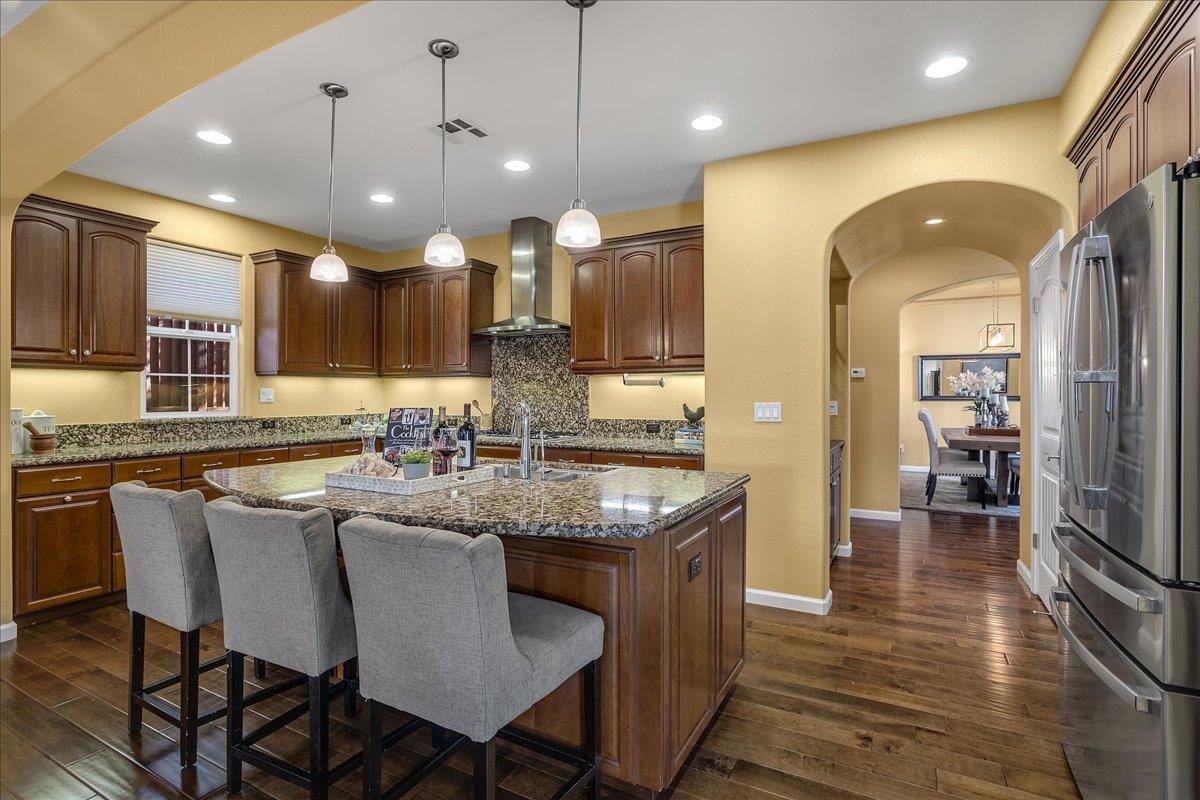 7626 Braid Court Gilroy, CA 95020 - Photo 18 of 49 a kitchen with stainless steel appliances granite countertop a kitchen island a stove a sink a dining table and chairs
