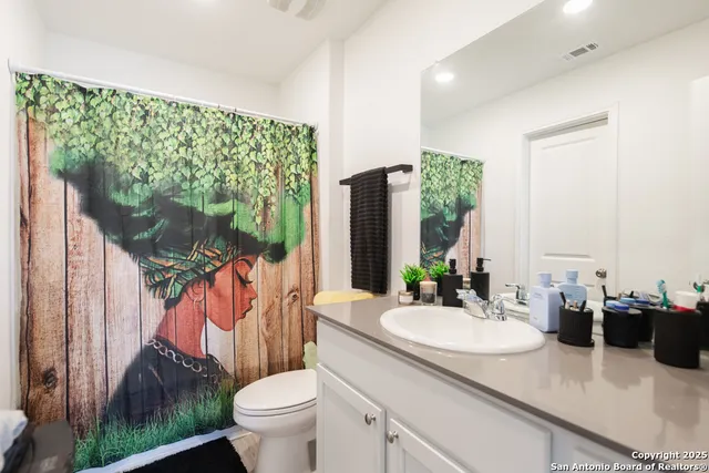 a bathroom with a sink toilet and a mirror