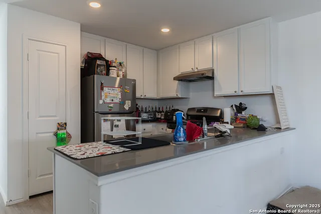 a kitchen with stainless steel appliances granite countertop a sink and a refrigerator