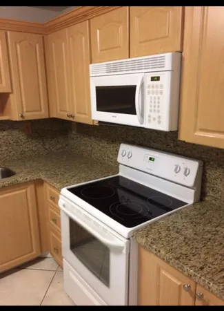 a kitchen with granite countertop cabinets stainless steel appliances and a sink