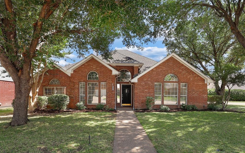 9449 Abbey Road Irving, TX 75063 - Photo 1 of 1 a front view of a house with a garden and trees