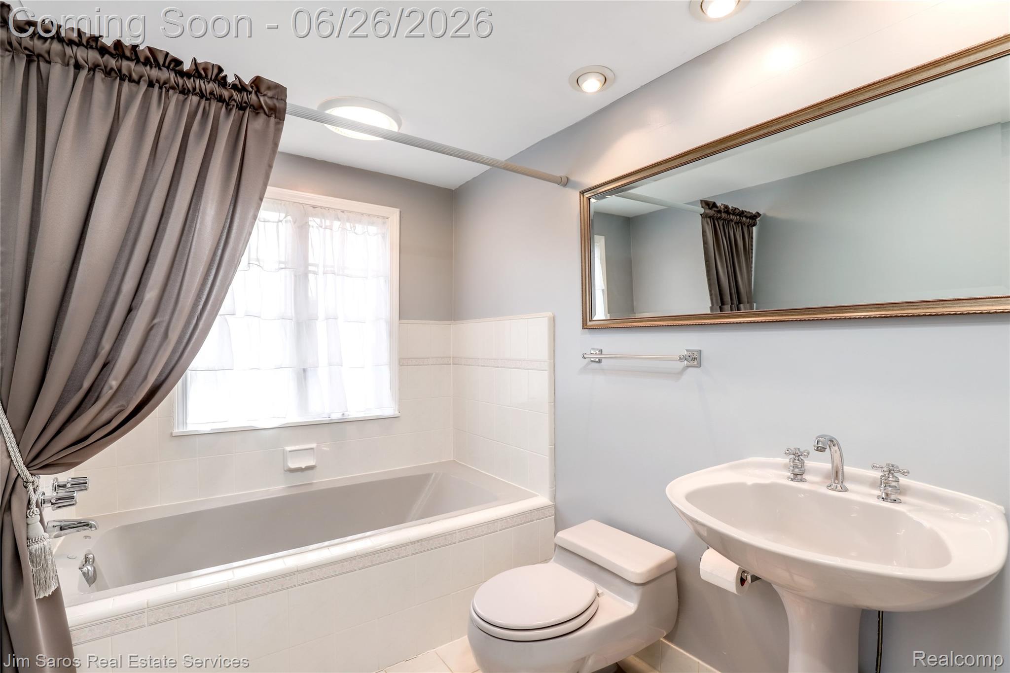 764 Harcourt Road Grosse Pointe, MI 48230 - Photo 32 of 42 Bathroom featuring a pedestal sink with chrome fixtures, a full-size bathtub with white tile surround, and a window for natural light