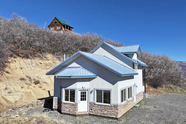 a view of white house with a yard and large tree