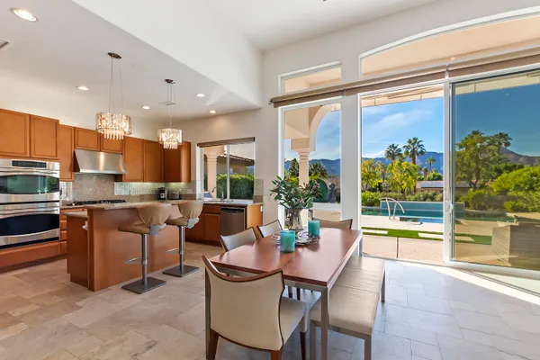 a dining room with stainless steel appliances granite countertop a stove and a view of living room