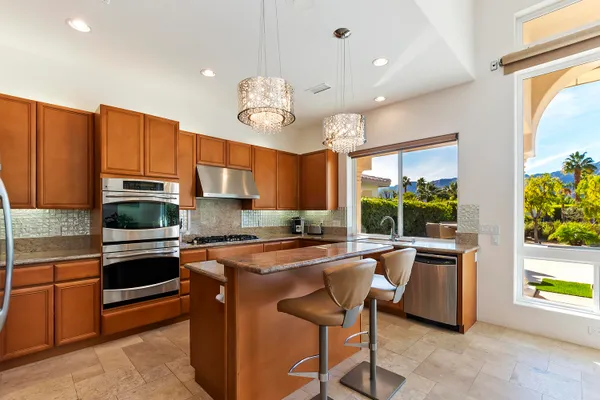 a kitchen with stainless steel appliances granite countertop a sink a stove and a refrigerator