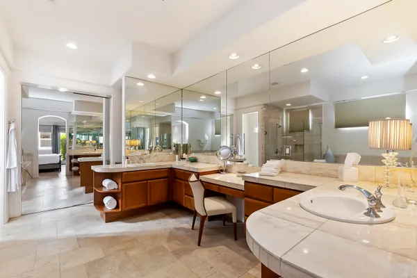 a room with lots of white furniture a flat screen tv and a view of living room