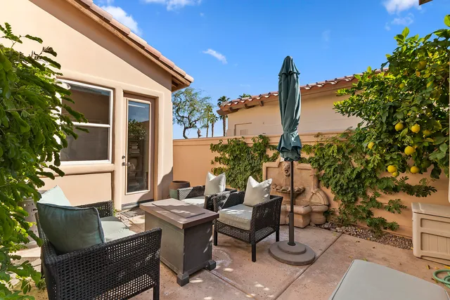 a view of a patio with couches table and chairs and potted plants