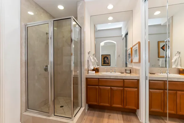 a bathroom with a double vanity sink mirror and shower