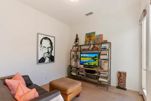 a living room with furniture a flat screen tv and a wall painting