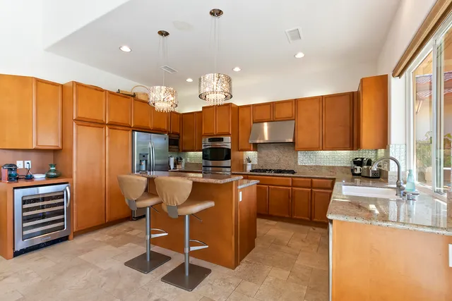 a kitchen with stainless steel appliances kitchen island granite countertop a sink and cabinets