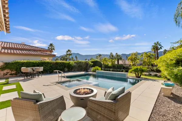 a view of a swimming pool with couches and lounge chairs