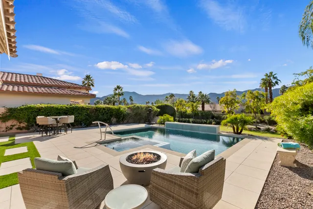 a view of a swimming pool with couches and lounge chairs
