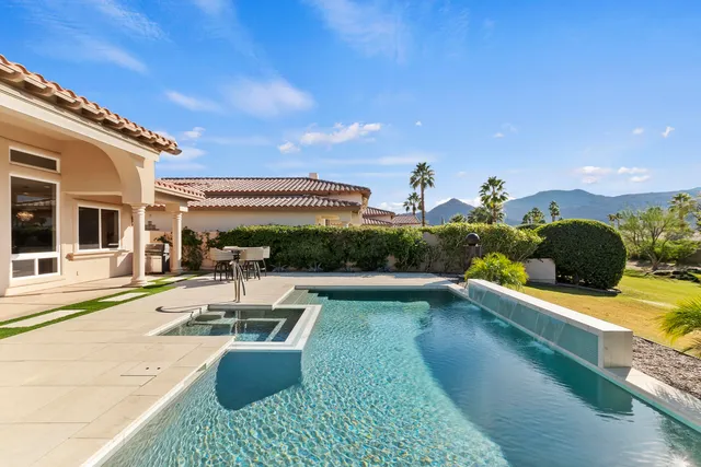 a view of a swimming pool with lawn chairs