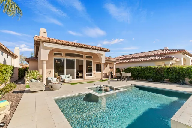 a front view of a house with swimming pool and furniture