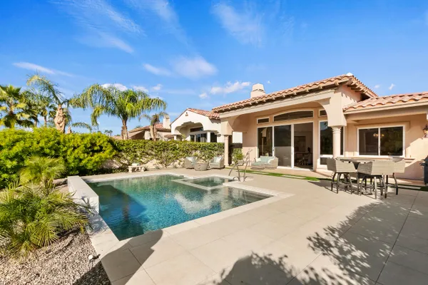 a view of a house with swimming pool and sitting area