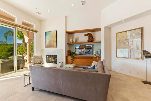 a living room with furniture a fireplace and a floor to ceiling window