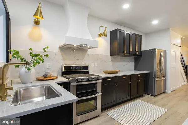 a kitchen with stainless steel appliances a stove a sink and a refrigerator