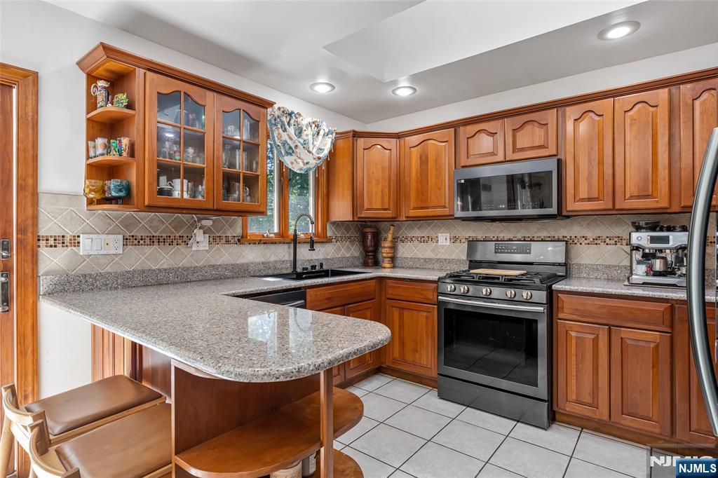 21 Marcia Road Ringwood, NJ 07456 - Photo 11 of 42 a kitchen with stainless steel appliances granite countertop a stove a sink and a microwave