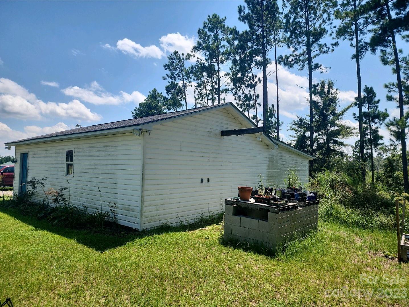 626 Union School Road McBee, SC 29101 - Photo 6 of 19 a view of a backyard with potted plants and a large tree