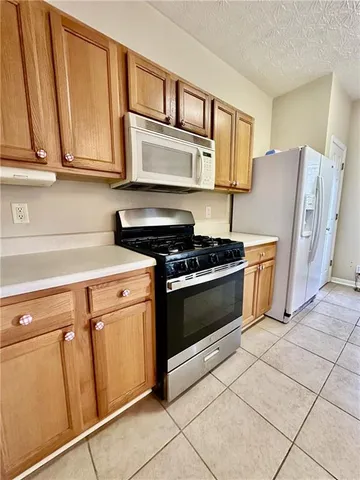 a kitchen with stainless steel appliances granite countertop a refrigerator stove and sink