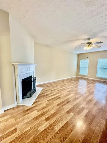 a view of a livingroom with wooden floor and a fireplace