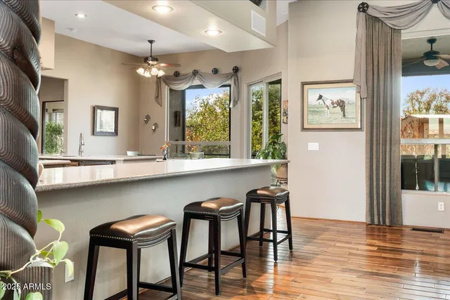 a living room with furniture floor to ceiling window and wooden floor