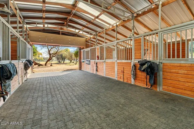 an aerial view of a house with swimming pool and large trees