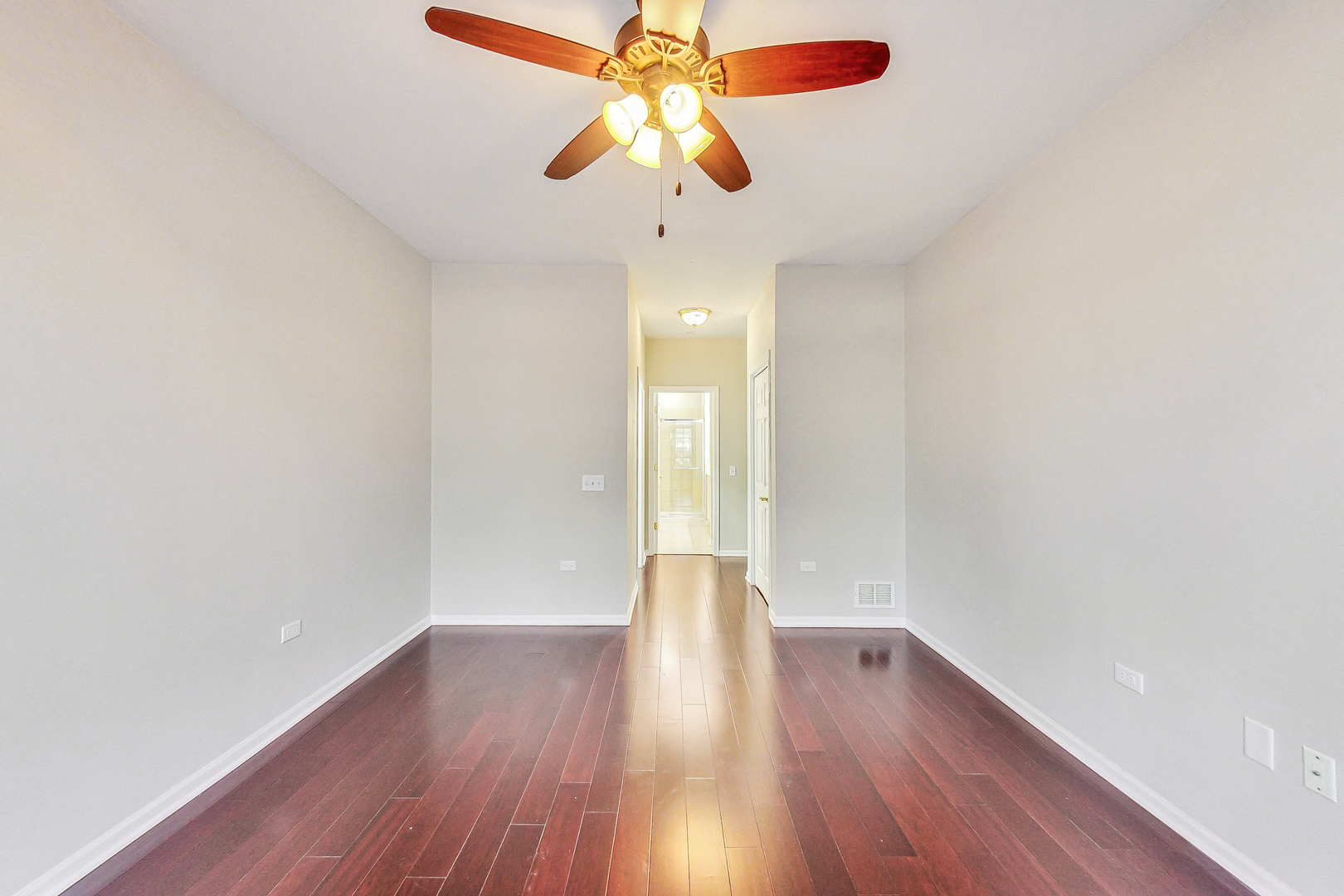 660 McHenry Road, Unit 1102 Wheeling, IL 60090 - Photo 11 of 19 a view of wooden floor and chandelier fan in a room