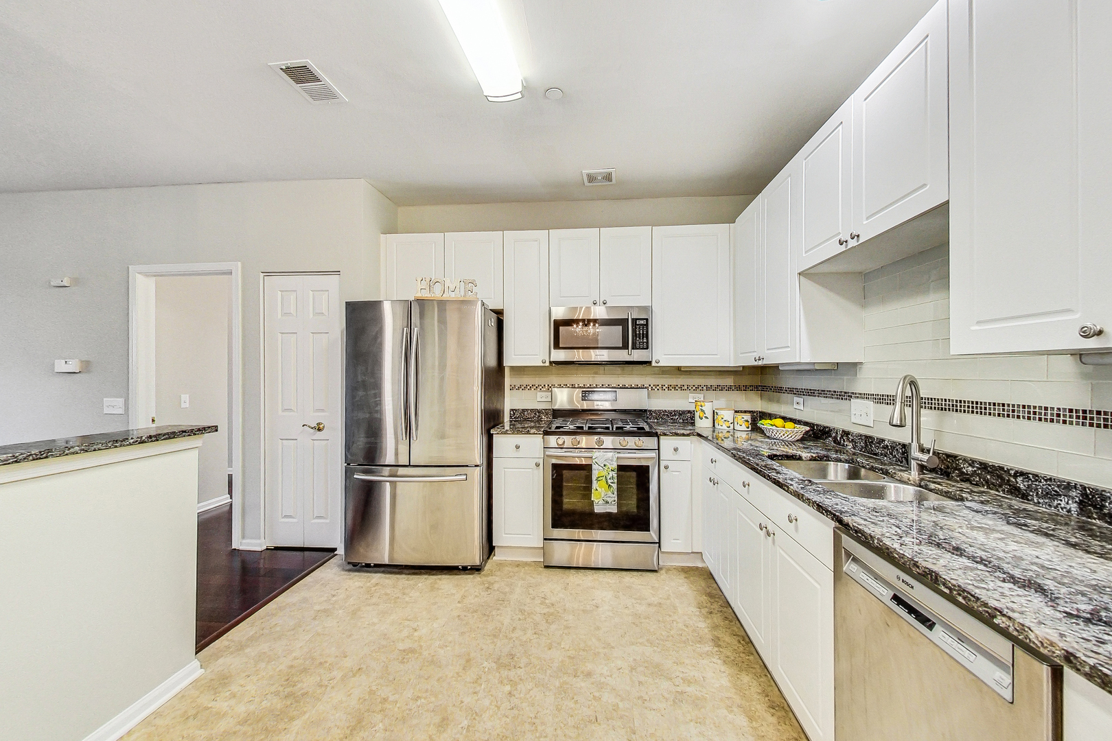 660 McHenry Road, Unit 1102 Wheeling, IL 60090 - Photo 5 of 19 a kitchen with stainless steel appliances granite countertop a stove top oven a refrigerator a sink and dishwasher