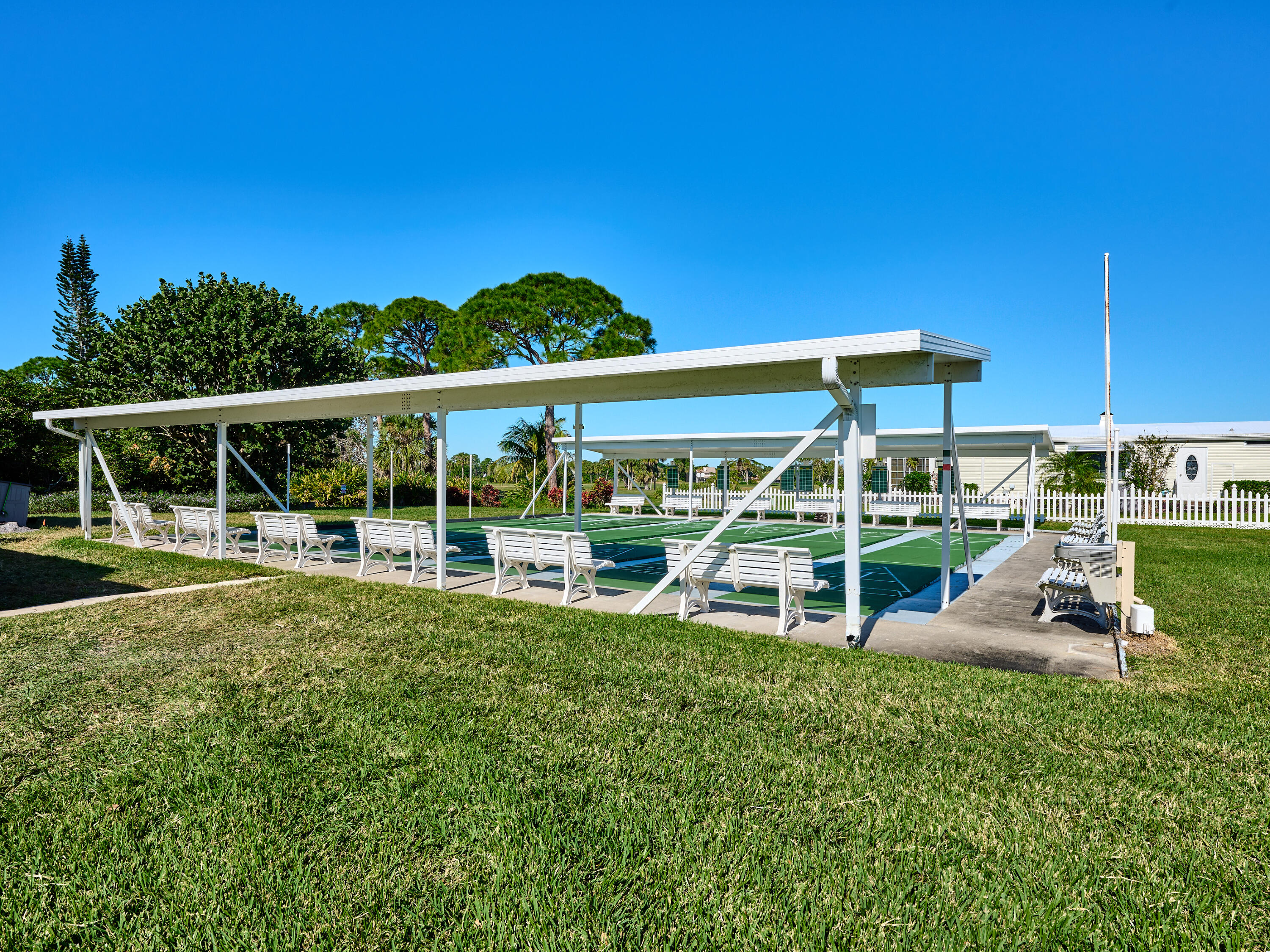 6977 Southeast Delegate Street Hobe Sound, FL 33455 - Photo 60 of 60 a view of a chair and tables in the back yard of the house