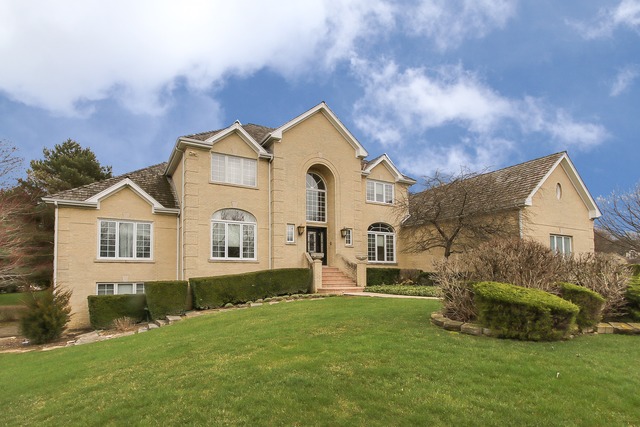 a front view of a house with a garden and yard