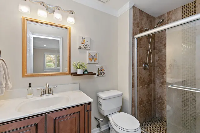 a bathroom with a sink vanity granite toilet and shower