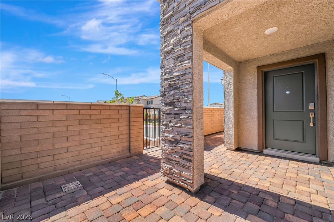 894 Cadence View Way Henderson, NV 89011 - Photo 3 of 23 A welcoming paver courtyard with stone accents leads to the inviting entryway.