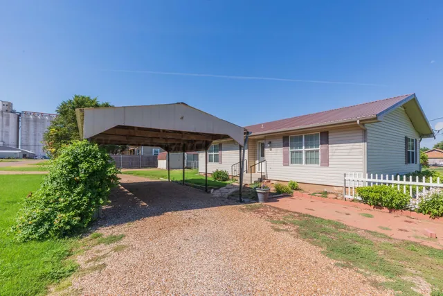 a front view of a house with a yard and potted plants