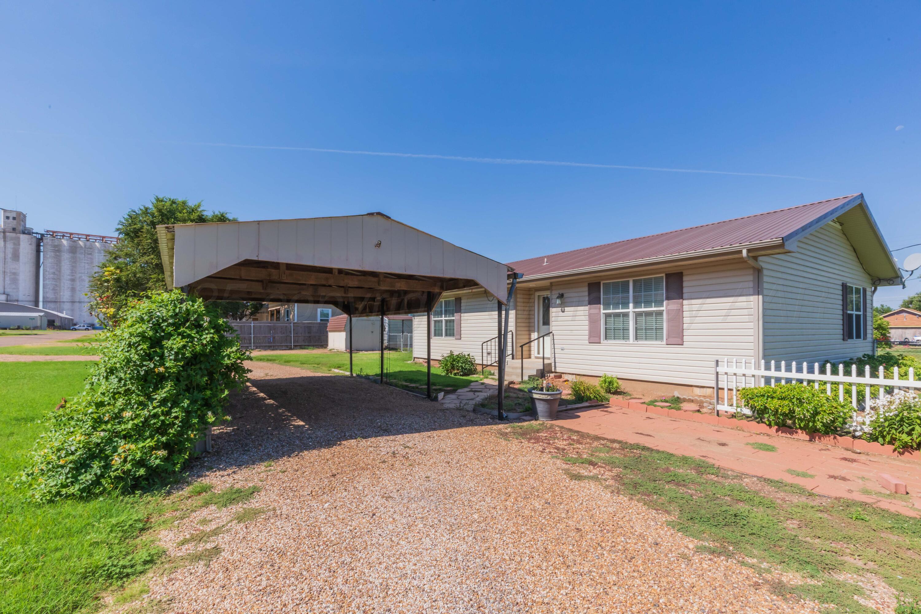 a front view of a house with a yard and potted plants