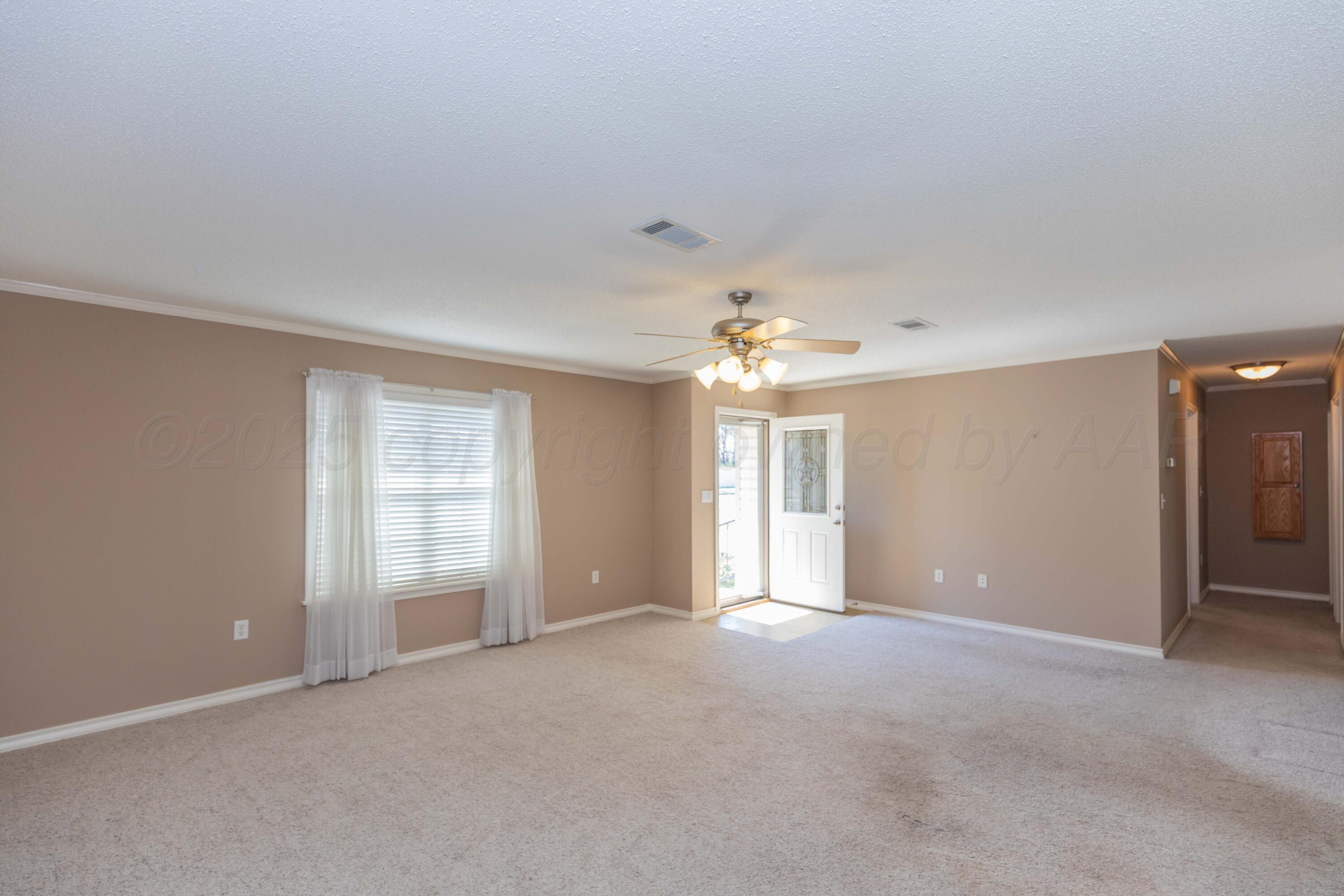 109 Texas Avenue Groom, TX 79039 - Photo 11 of 21 an empty room with chandelier fan and windows