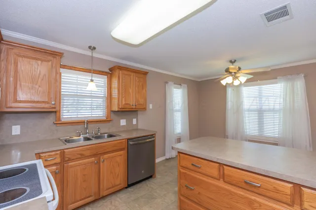 a kitchen with stainless steel appliances granite countertop a sink a stove and a window