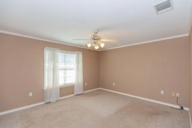 an empty room with chandelier fan and windows