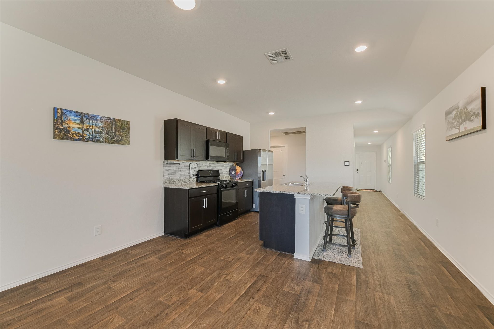 232 Euclid Lane Kyle, TX 78640 - Photo 5 of 15 a kitchen with stainless steel appliances wooden floors and wooden cabinets