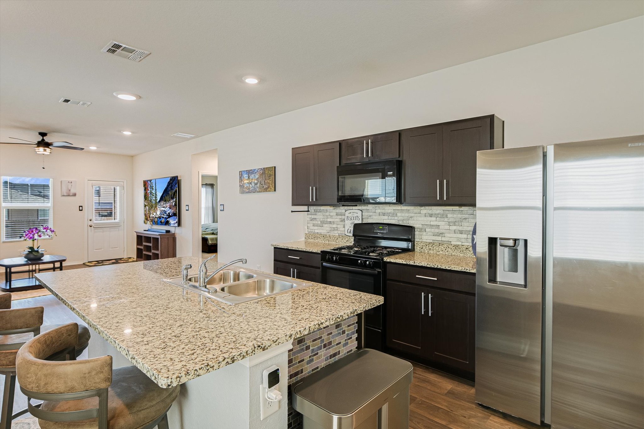 232 Euclid Lane Kyle, TX 78640 - Photo 7 of 15 a kitchen with granite countertop kitchen island stainless steel appliances a refrigerator sink and stove